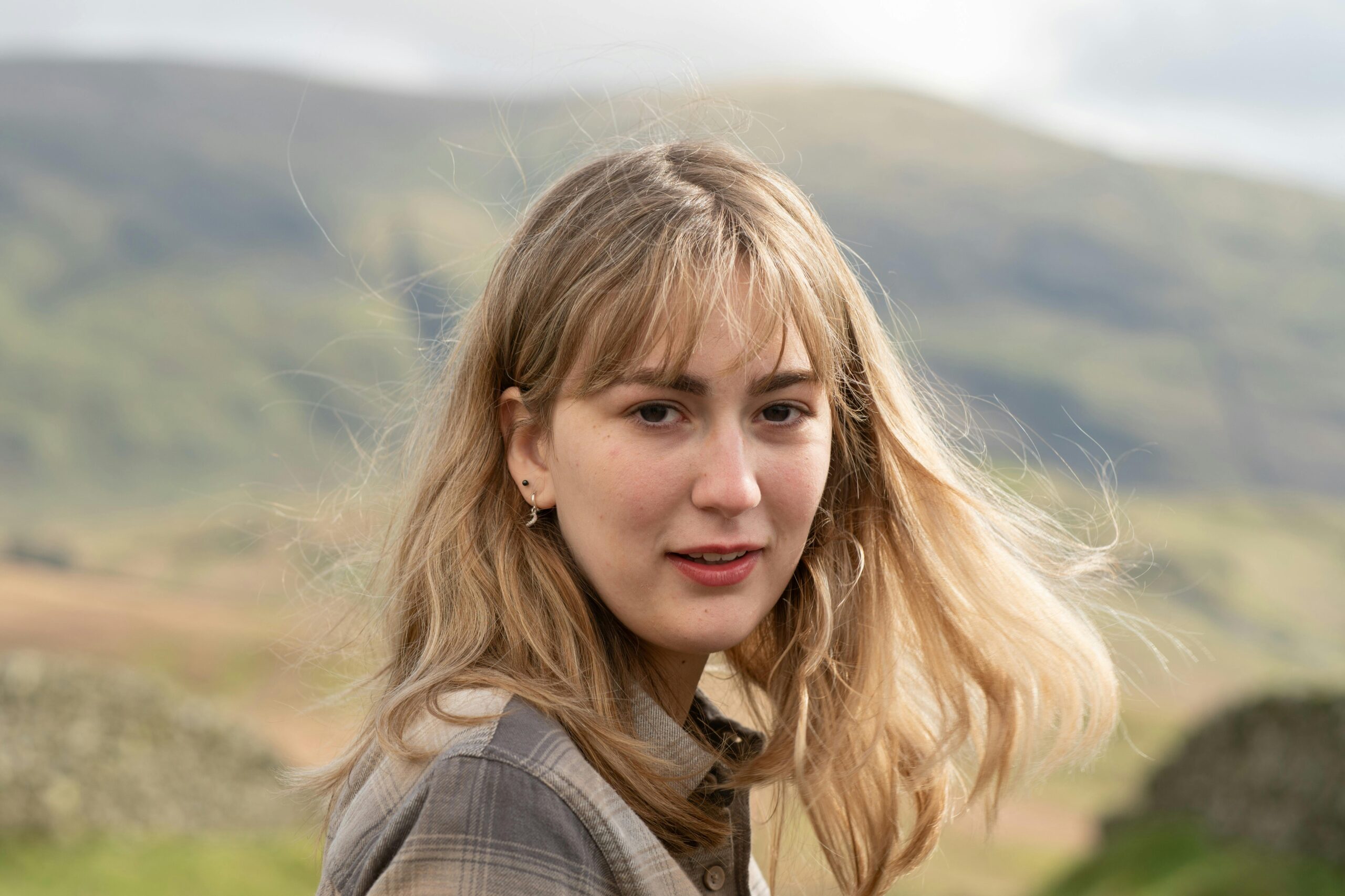 Agile & Scrum Certifications A woman with blonde hair poses in the windy hills of Windermere, England.